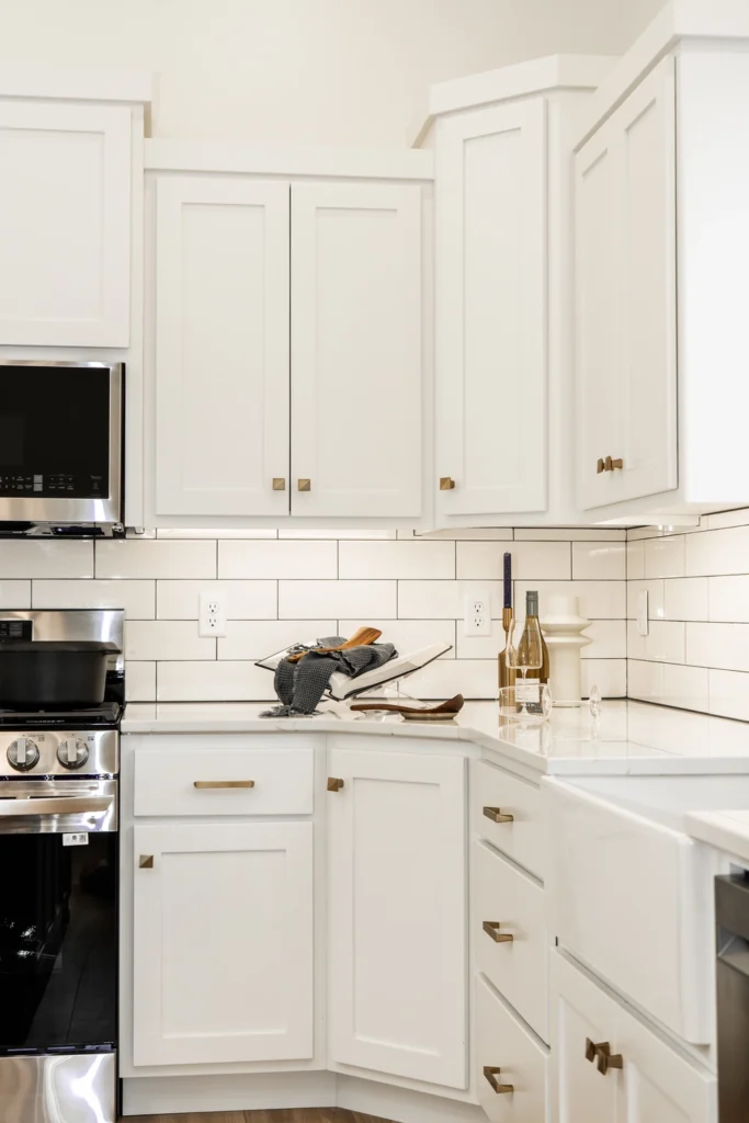 Modern kitchen design featuring white cabinetry, stainless steel appliances, and elegant decor elements, showcasing a custom home interior by Paragon Homes.