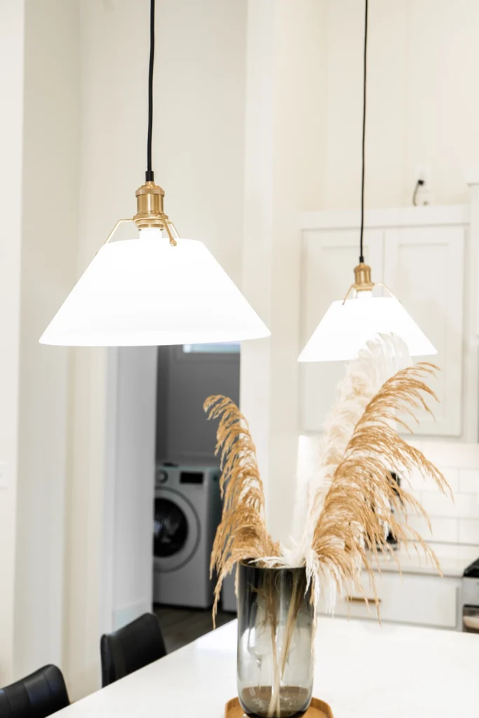 Modern kitchen featuring elegant pendant lights and a decorative vase with dried pampas grass, showcasing a stylish interior design suitable for custom homes in Fargo, ND.