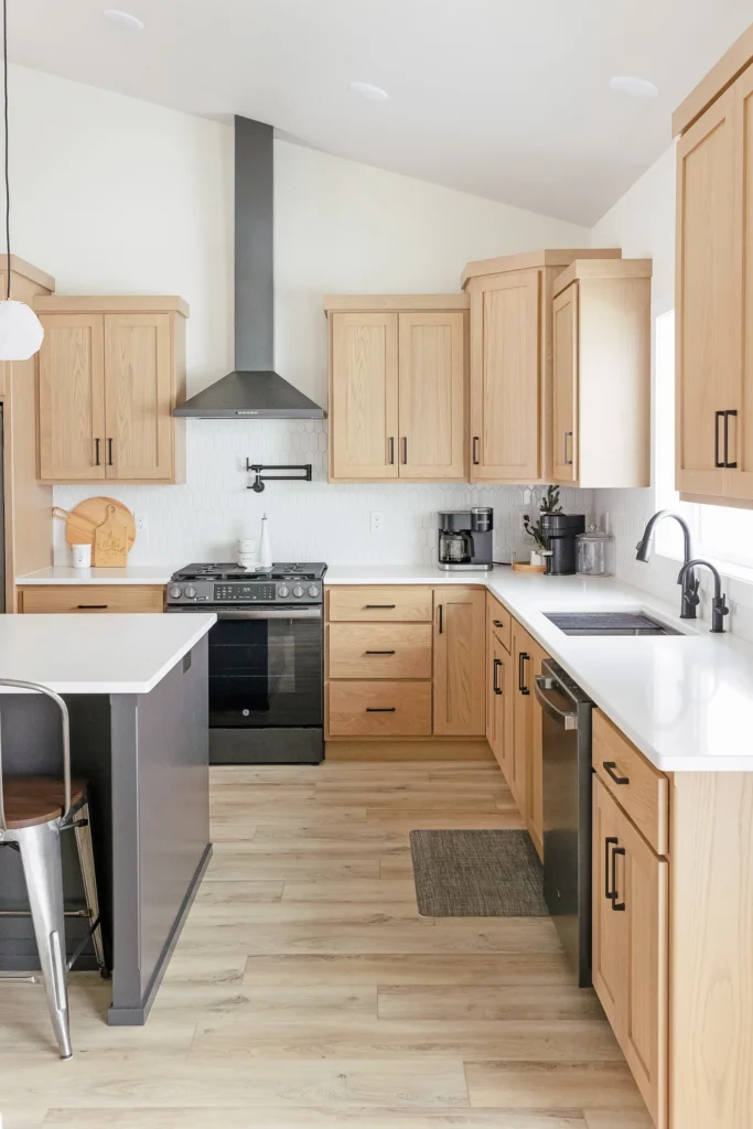 Modern kitchen design featuring light wood cabinetry, stainless steel appliances, and a spacious layout, showcasing a blend of functionality and style for custom home building in Fargo-Moorhead.